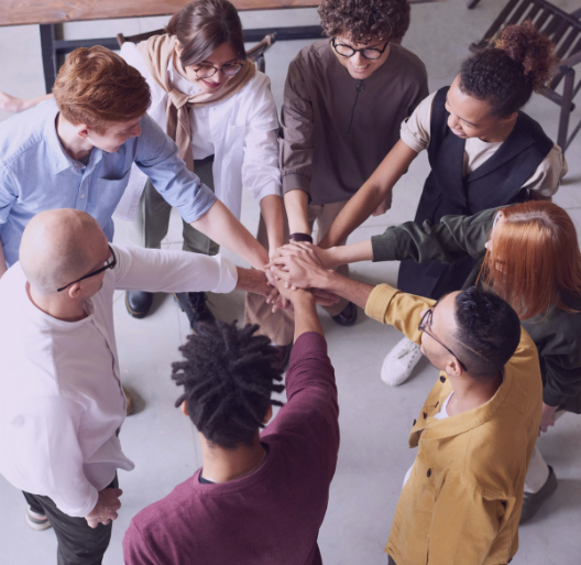 Equipo de personas diversas mostrando trabajo en equipo y colaboración.